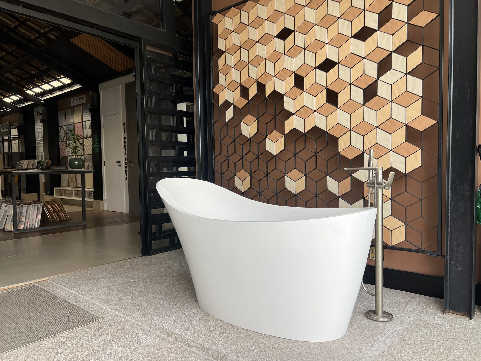 Banheira de imersão diante de painel de revestimento hexagonal no showroom