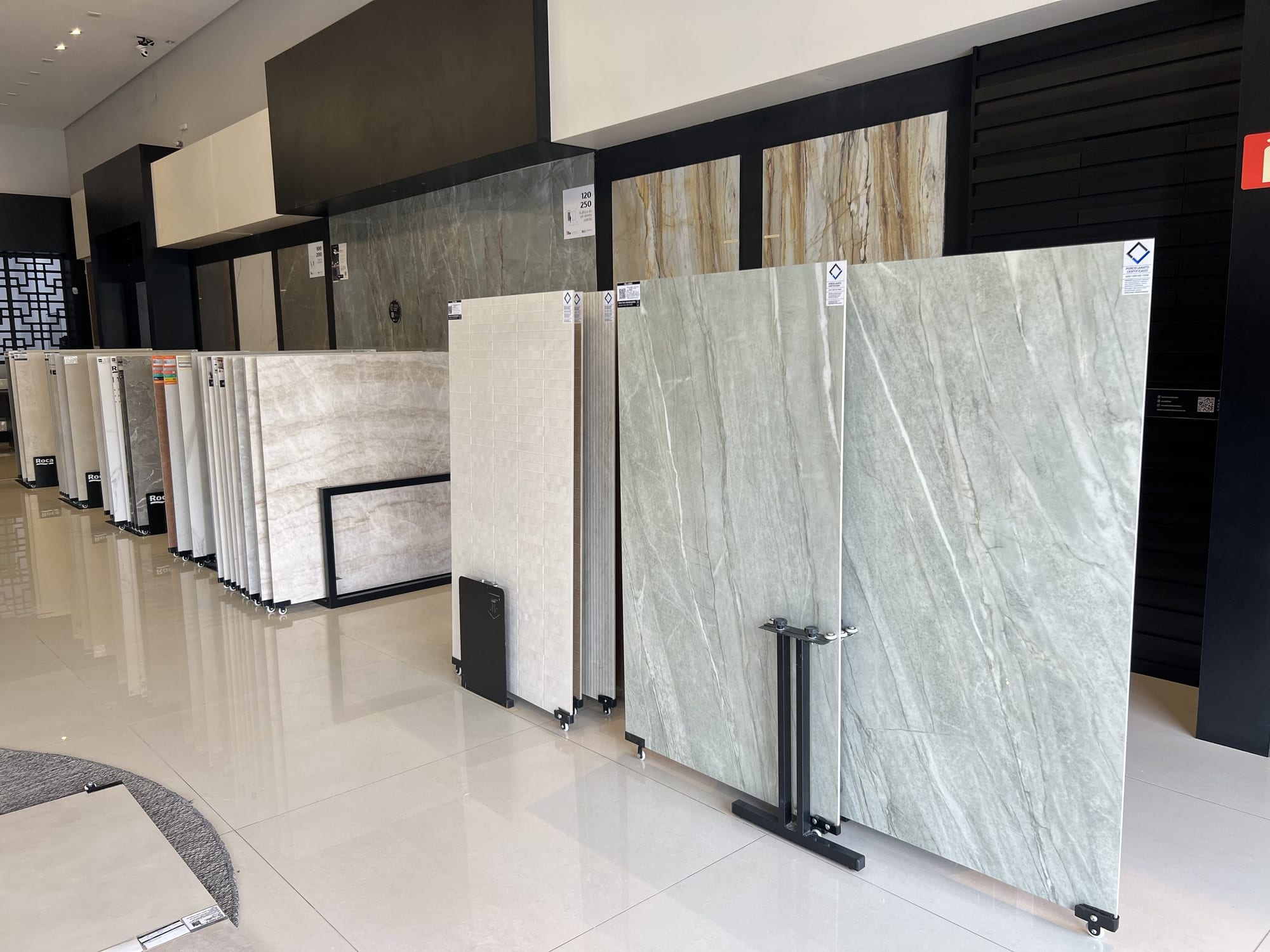 Chapas de porcelanato e pedra em grande formato expostas em cavaletes
